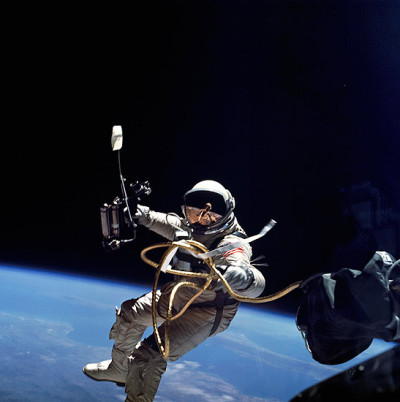 vemos a un hombre con trjaje espacial con casco  y botas que flota en el espacio